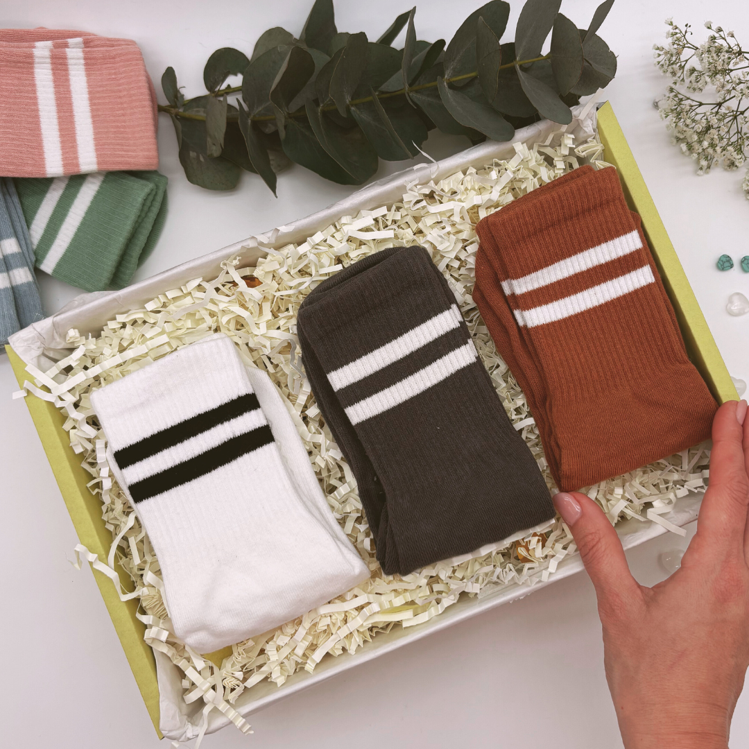 Yoga and pilates socks gift set. A gift box containing three pairs of grip socks in white, brown, and green colours, designed for yoga and pilates with plastic nobbles for grip.