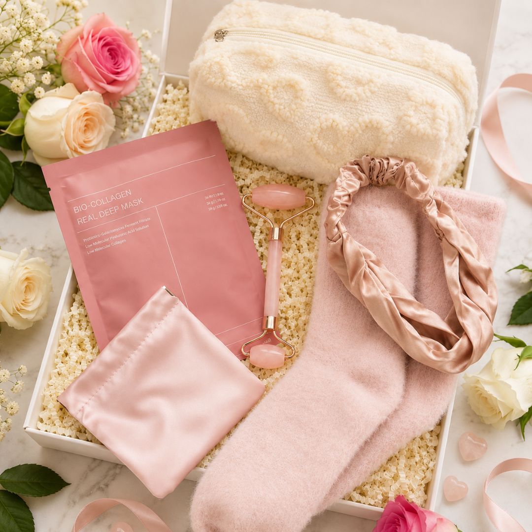 Skincare products including a pink mask, roller, and headband on a decorative surface with flowers.