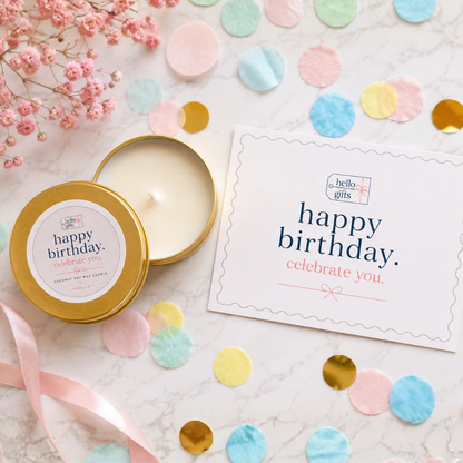 A round gold tin candle with cream-colored wax sits beside a printed &