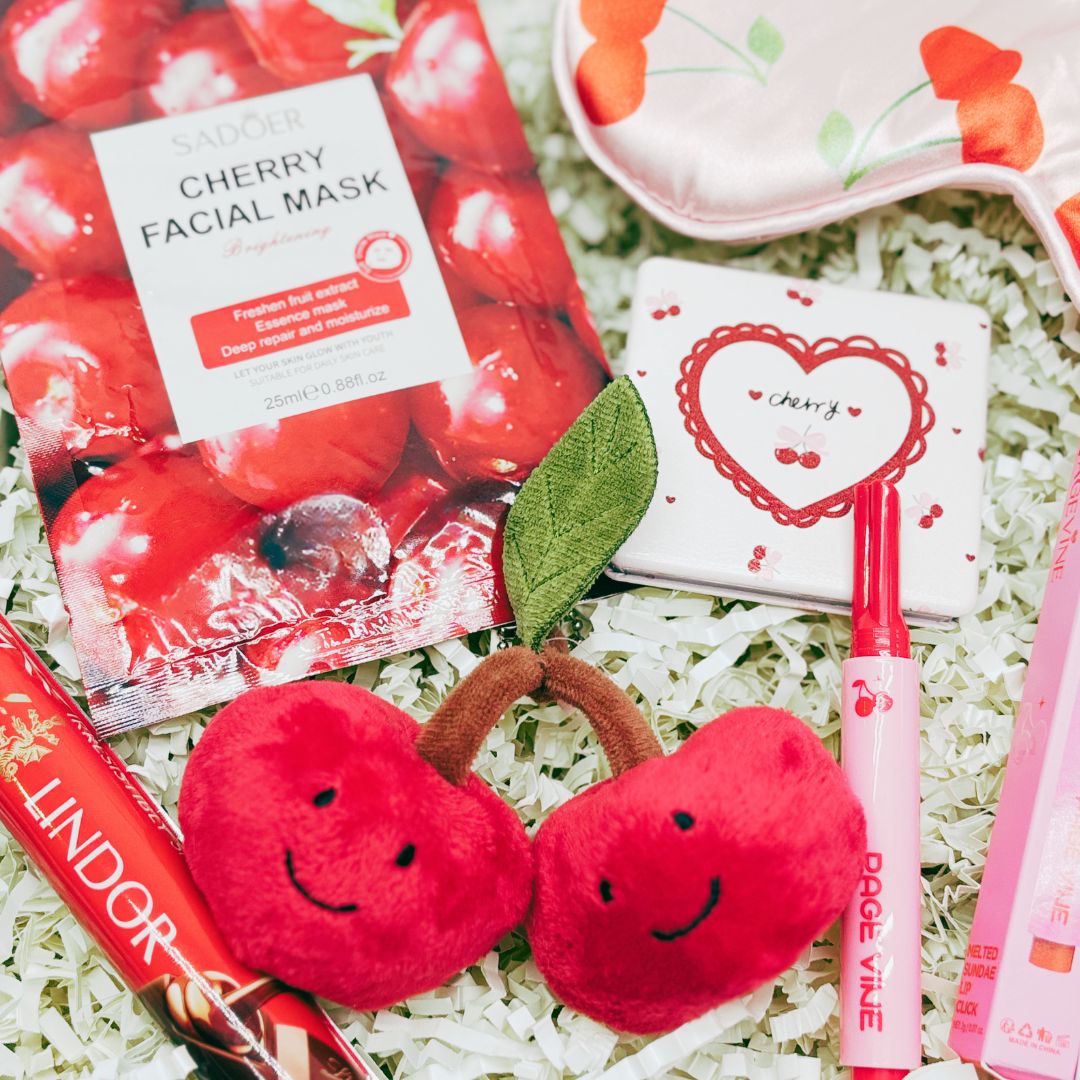 Collection of cherry-themed products including a facial mask, plush toys, and stationery items on a white background.
