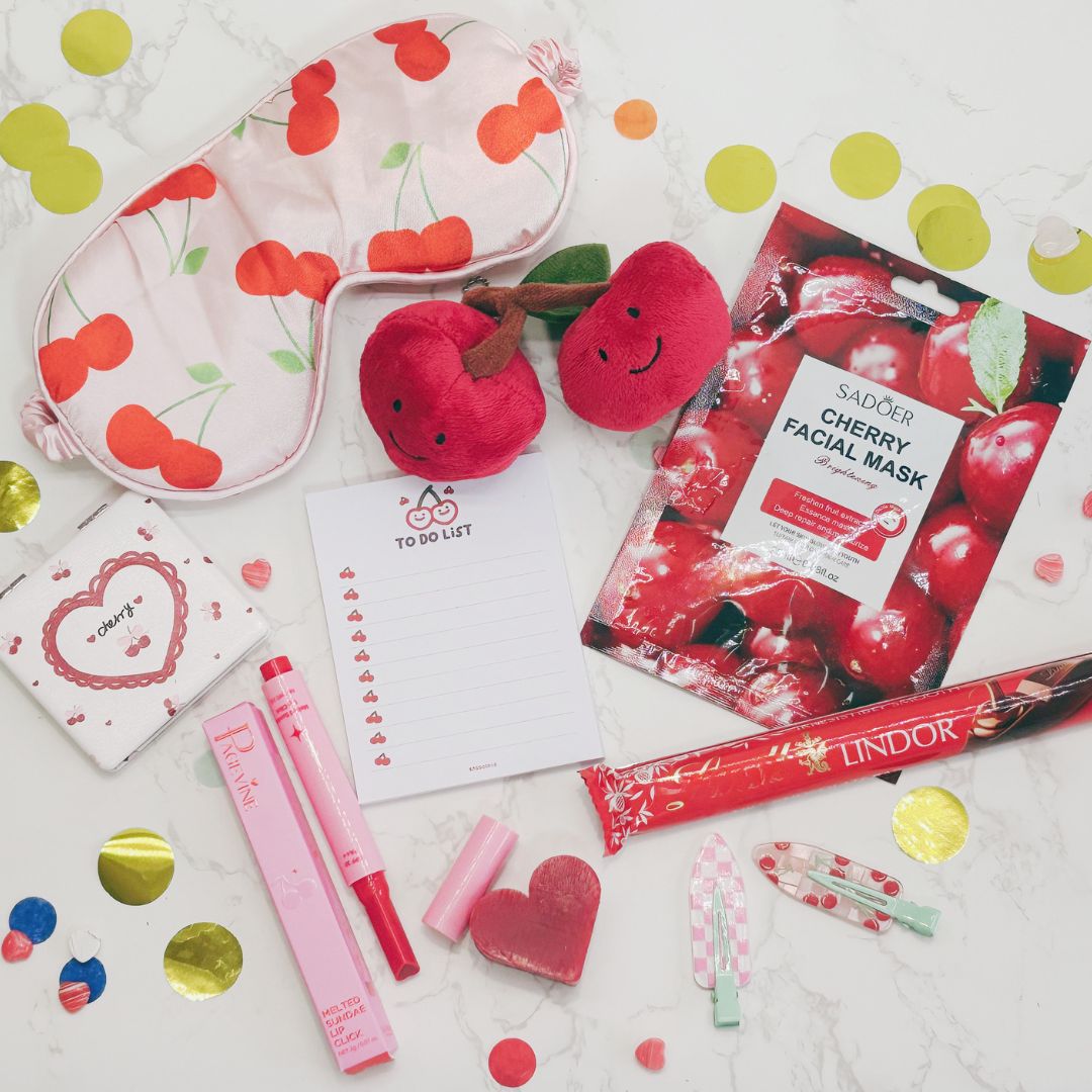 Cherry-themed products including facial masks, plush toys, and stationery items on a white background with colorful dots.