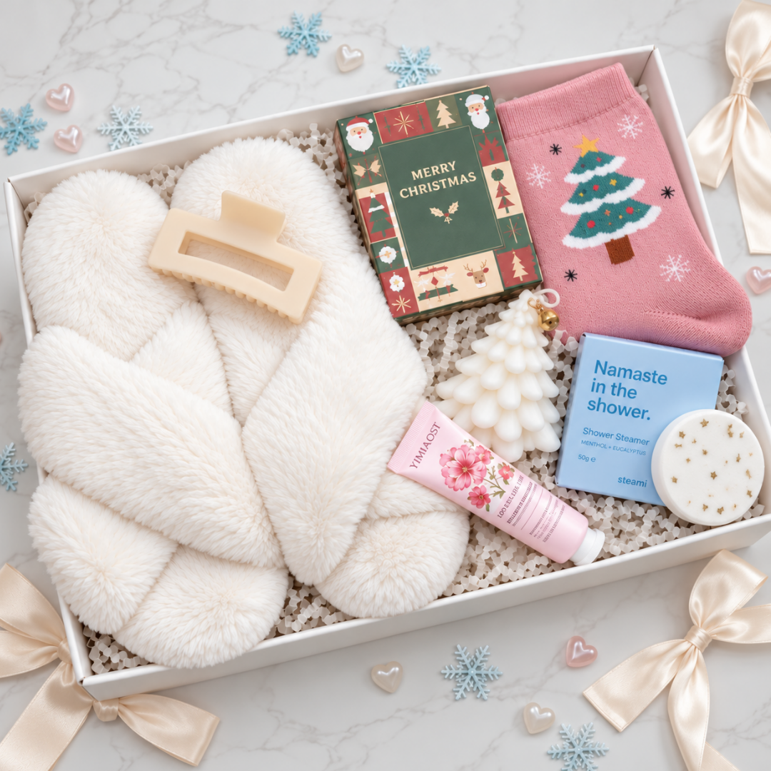 A curated gift box set containing a fluffy white slipper, a pink Christmas-themed sock, a green &