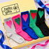 Five pairs of crew socks in gray, pink, blue, green, and black, each with a contrasting heart on the front, displayed inside a yellow Hello Gifts box with shredded paper filler and ribbon accents.