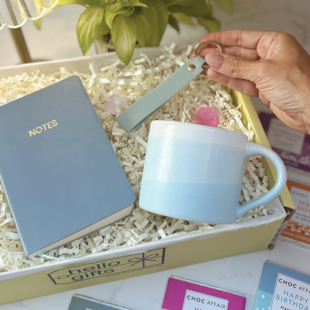 Light blue mug, keyring and notebook in a gift box.