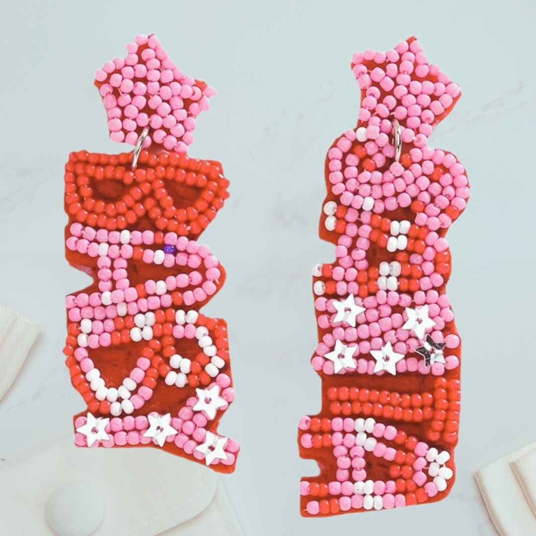 Christmas Earrings. Santa baby beaded earrings. Pair of beaded earrings with red, pink, and white design on a light gray background