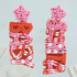 Christmas Earrings. Santa baby beaded earrings. Pair of beaded earrings with red, pink, and white design on a light gray background