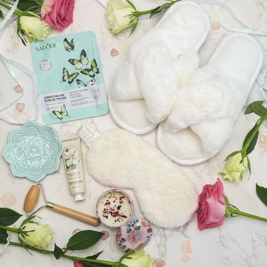 Skincare products including face masks, cream, and scrub with flowers on a marble surface