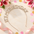A rhinestone-embellished headband spelling &