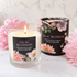 A lit glass jar candle labeled &