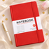 A red hardcover notebook with a white paper band label reading &